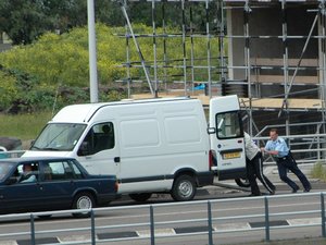 twee motoragenten duwen motor busje in